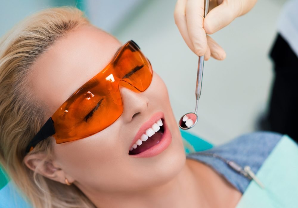 Close up photo of a woman visiting to the dentist. Teeth whitening concept